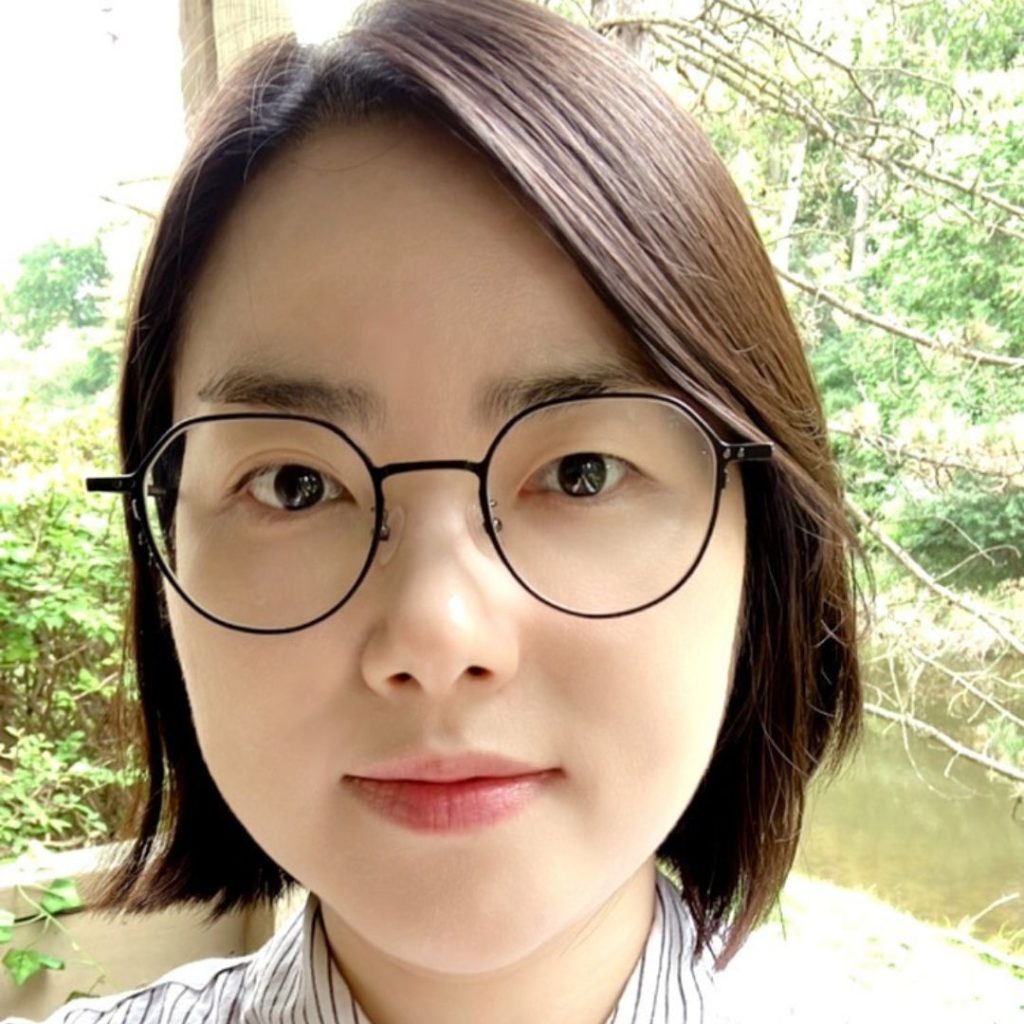 Portrait of a woman with short brown hair and eyeglasses.