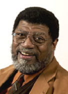 man in beige suit with beard and glasses