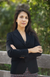 woman in blazer standing near wooden railing
