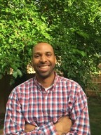 man in plaid shirt smiling outside