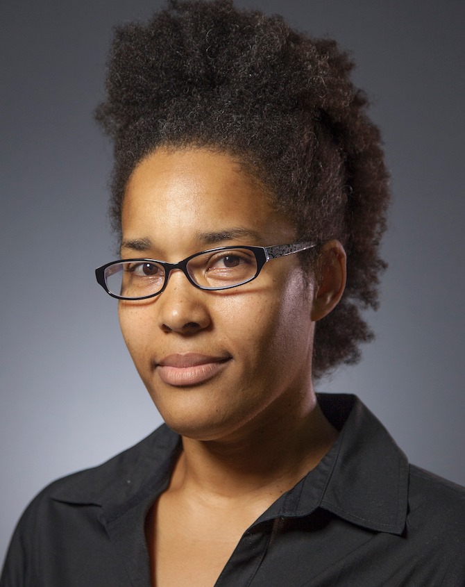 a woman with dark hair wearing glasses and a black button down